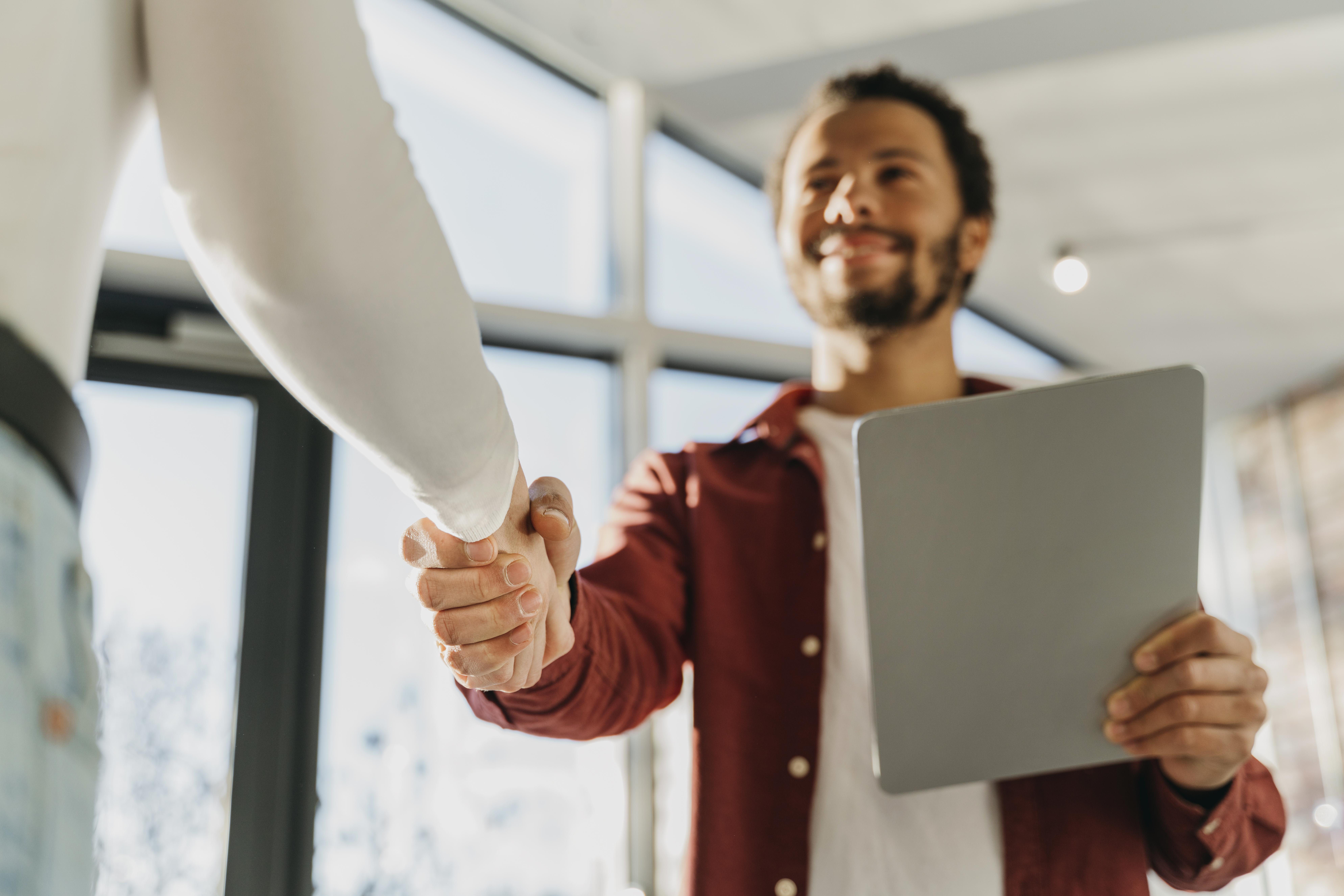 Two people shaking hands, symbolizing a job opportunity or partnership